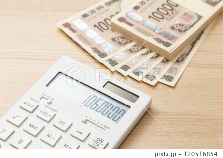 テーブルに置かれた106万円と電卓 テーブルに置かれた106万円と電卓 120516854