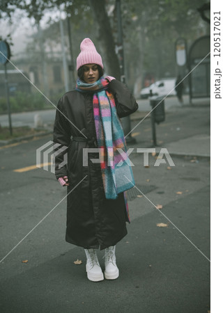 A woman elegantly wears a bright pink hat and matching scarf 120517021