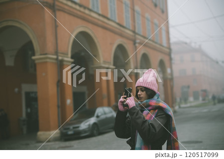 A woman is taking a picture of a beautiful building with a camera 120517099