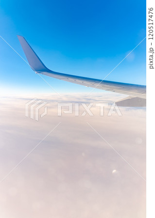 View from the airplane window at a beautiful cloudy sky and the airplane wing 120517476