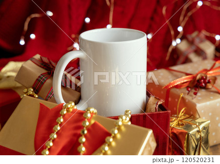 White coffee mug in gift box near red Christmas decor and lights, winter mockup White coffee mug in gift box near red Christmas decor and lights, winter mockup 120520231