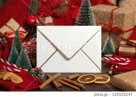 White envelope near Christmas decor, trees, spices and red knitted sweater, winter mockup 120520247