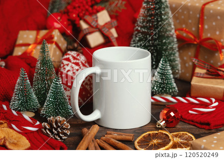 White ceramic coffee mug near Christmas decor, trees, spices and red sweater, mockup 120520249