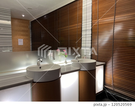 Clean new public bathroom with white washbasin and taps. Public restroom interior. Clean new public bathroom with white washbasin and taps. Public restroom interior. 120520569