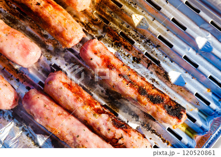 Sausages meat grilling on gas grill 120520861