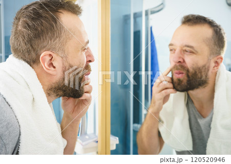 Man looking at his beard in mirror 120520946