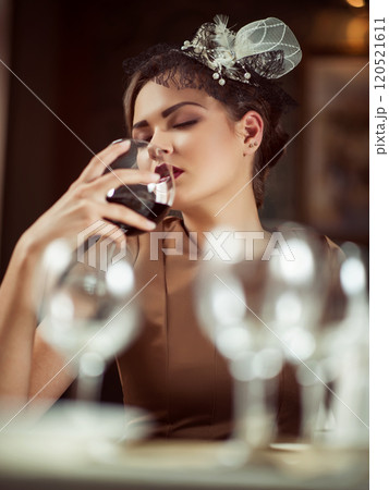 Beautiful young woman drinking red wine with friends in cafe Beautiful young woman drinking red wine with friends in cafe 120521611
