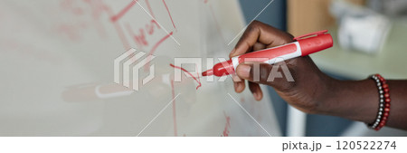 Close-up view of hand holding red marker and writing on whiteboard during a presentation in classroom environment detailed diagrams being sketched on board 120522274