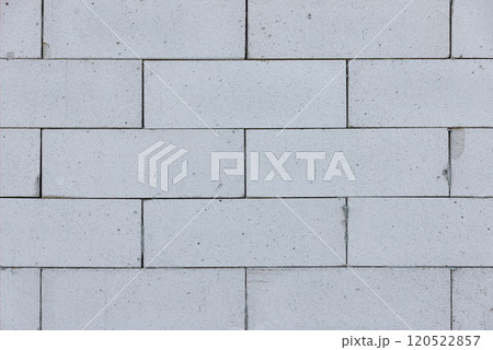 Sturdy white bricks form an intricate wall pattern in natural light at midday, showcasing texture 120522857
