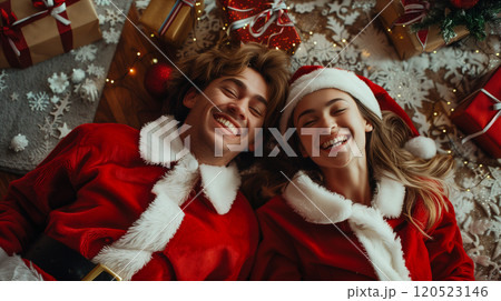 Laughing Couple On Their Backs Wearing Matching Holiday Pajamas Surrounded By Christmas Gifts. Generative AI. 120523146