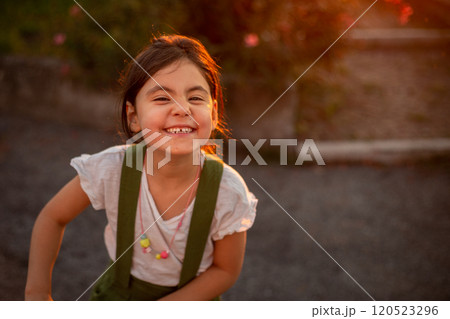 close-up portrait of smiling girl standing in the park looking at camera close-up portrait of smiling girl standing in the park looking at camera 120523296