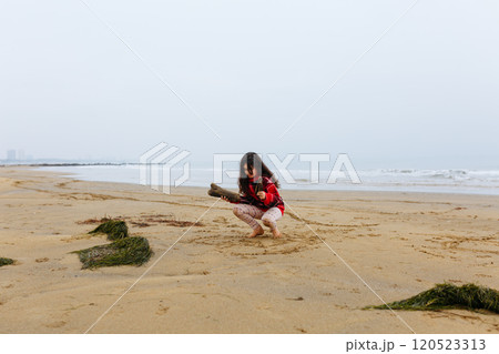 upper view of one child playing at the sand beach in front of sea upper view of one child playing at the sand beach in front of sea 120523313