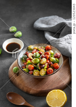 Fried brussels sprouts with nuts in soy sauce on a dark background. Concept nutritious asian dish Fried brussels sprouts with nuts in soy sauce on a dark background. Concept nutritious asian dish 120523843
