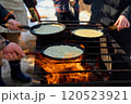 Cooking traditional Russian food, pancakes, in frying pans outside, on an open fire. Celebrating Carnival 120523921