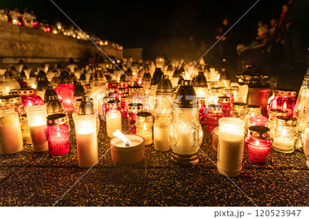 Rows of glowing cemetery candles at night during All Saints Day. A beautiful tribute to honor and remember the departed, creating a serene and reflective atmosphere of remembrance and light 120523947