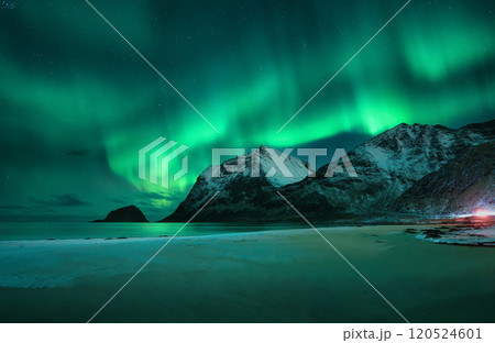Aurora borealis on night sky over snowy mountains and sandy beach 120524601