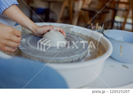 Creating artisan pottery on a wheel involves a meticulous process that showcases craftsmanship Creating artisan pottery on a wheel involves a meticulous process that showcases craftsmanship 120525207