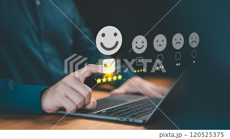 Customer selects a happy smile face icon on a virtual screen on a laptop, signaling satisfaction in service. Concept of assessment, testimonial, customer service feedback, and opinion rating. 120525375