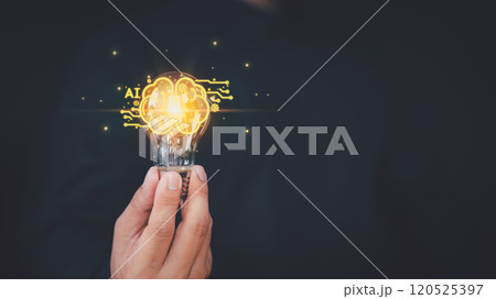 Close-up of a hand holding a glowing light bulb with ai and brain sign against a dark background, symbolizing creativity, innovation, and new ideas. Close-up of a hand holding a glowing light bulb with ai and brain sign against a dark background, symbolizing creativity, innovation, and new ideas. 120525397