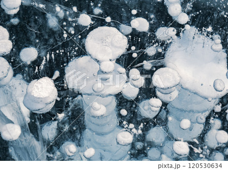 Bubbles trapped in ice on the surface of Lake Baikal during winter, showcasing unique natural formations in Siberia Bubbles trapped in ice on the surface of Lake Baikal during winter, showcasing unique natural formations in Siberia 120530634