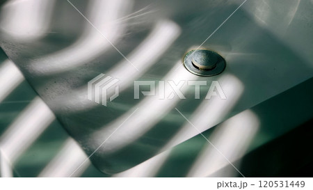 The bathroom sink and the sunlight coming through the blinds 120531449