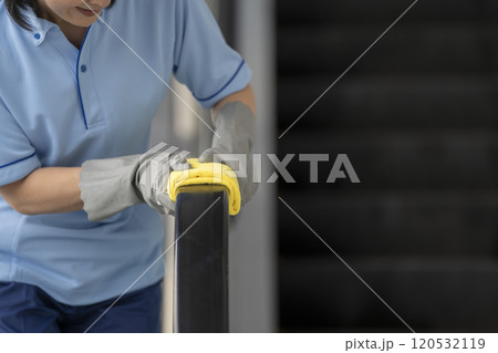 エスカレーターの手すりを拭く清掃スタッフの手元 120532119
