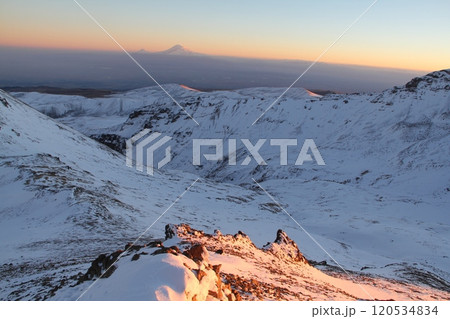 Stunning Snowy Mountain Landscape with Clear Blue Sky and Prominent Peak in the Distance 120534834
