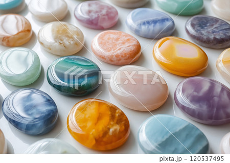 Smooth, oval gemstones in vibrant pastel colors with glossy finishes laid out in neat rows Smooth, oval gemstones in vibrant pastel colors with glossy finishes laid out in neat rows 120537495