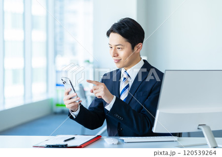 オフィスでスマホを操作するビジネスマン 120539264