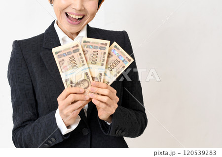 一万円の札束を持ち喜ぶスーツ姿の中年女性 一万円の札束を持ち喜ぶスーツ姿の中年女性 120539283