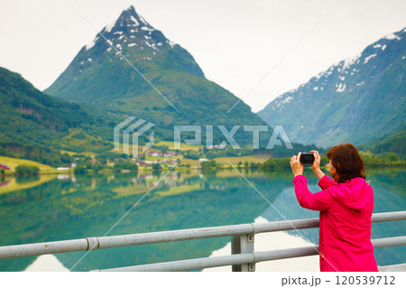 Tourist taking photo at norwegian fjord lake 120539712