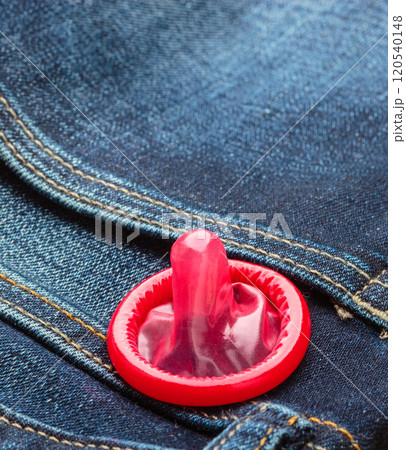 Closeup red condom on jeans pocket. Closeup red condom on jeans pocket. 120540148