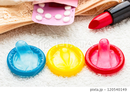 Pills condoms and lipstick on lace lingerie 120540149