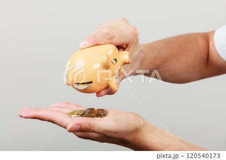 Male hands with coins and piggybank 120540173