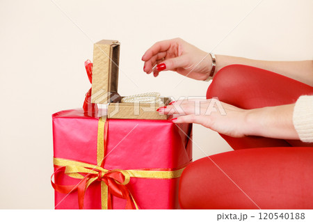 Female hands opening golden gift box with jewel pearls 120540188