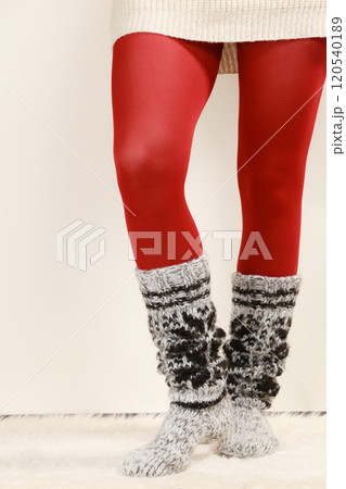 Woman legs wearing woolen socks and red tights 120540189