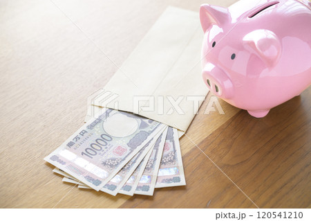 ブタの貯金箱と封筒に入れられたお札（新紙幣） 120541210