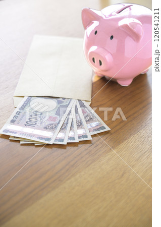 ブタの貯金箱と封筒に入れられたお札（新紙幣） 120541211