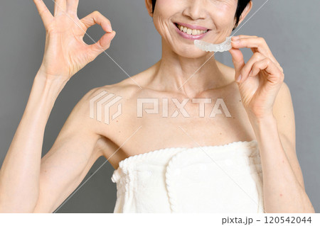 マウスピースを手に持ちOKする中年女性 マウスピースを手に持ちOKする中年女性 120542044