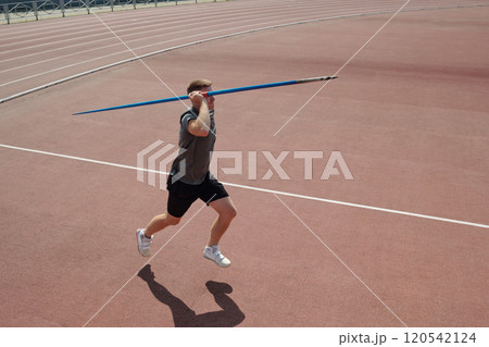 Athlete Practicing Javelin Throw on Outdoor Track Field 120542124