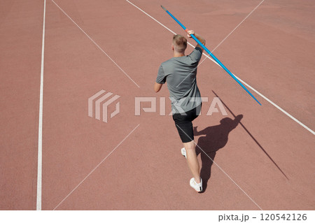 Athlete Practicing Javelin Throw on Track Field 120542126
