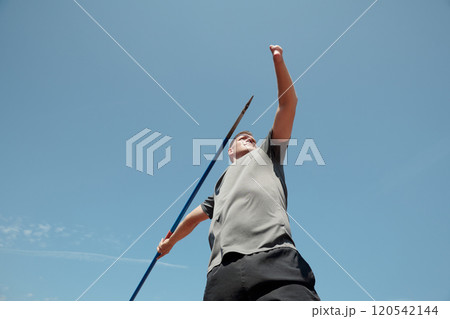 Athlete Practicing Javelin Throw at Outdoor Field 120542144