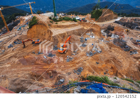 construction site with excavators digging pit for foundation of building under construction 120542152