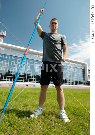 Holding Javelin on Green Field Under Clear Sky 120542153