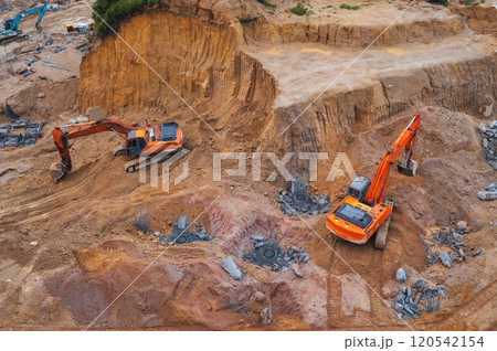 Excavators dig ground in foundation pit of building on a construction site. View from above 120542154