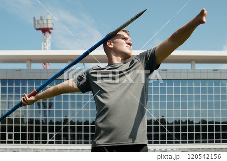 Holding Javelin on Sports Field with Determined Expression 120542156