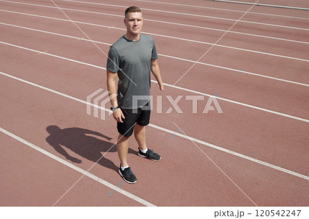 Running Athlete Standing on Track Field Preparing for Training 120542247