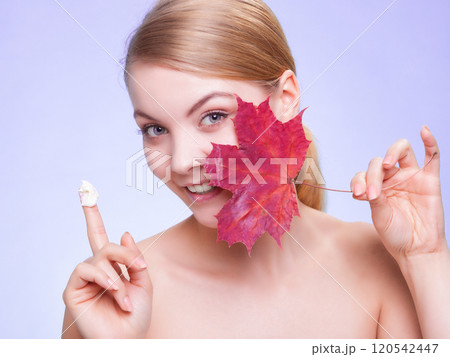 Skin care. Face of young woman girl with red maple leaf. 120542447