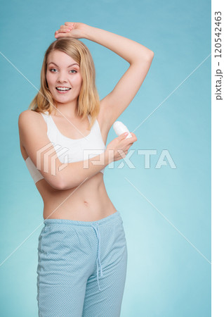 Girl applying stick deodorant in armpit. 120542463