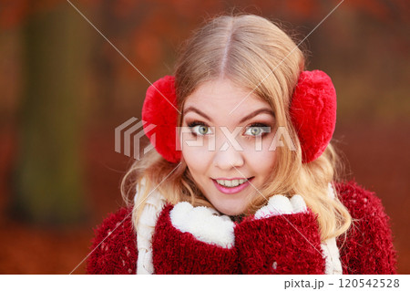 Portrait of pretty smiling woman in red earmuffs. 120542528